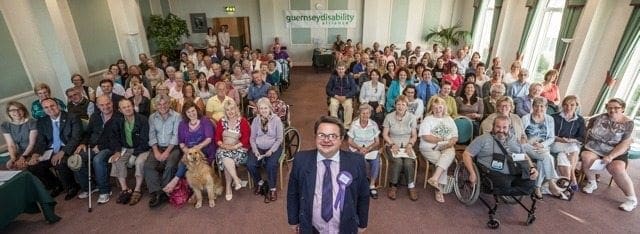 Deputy John Gollop in front of disabled islanders and their supporters